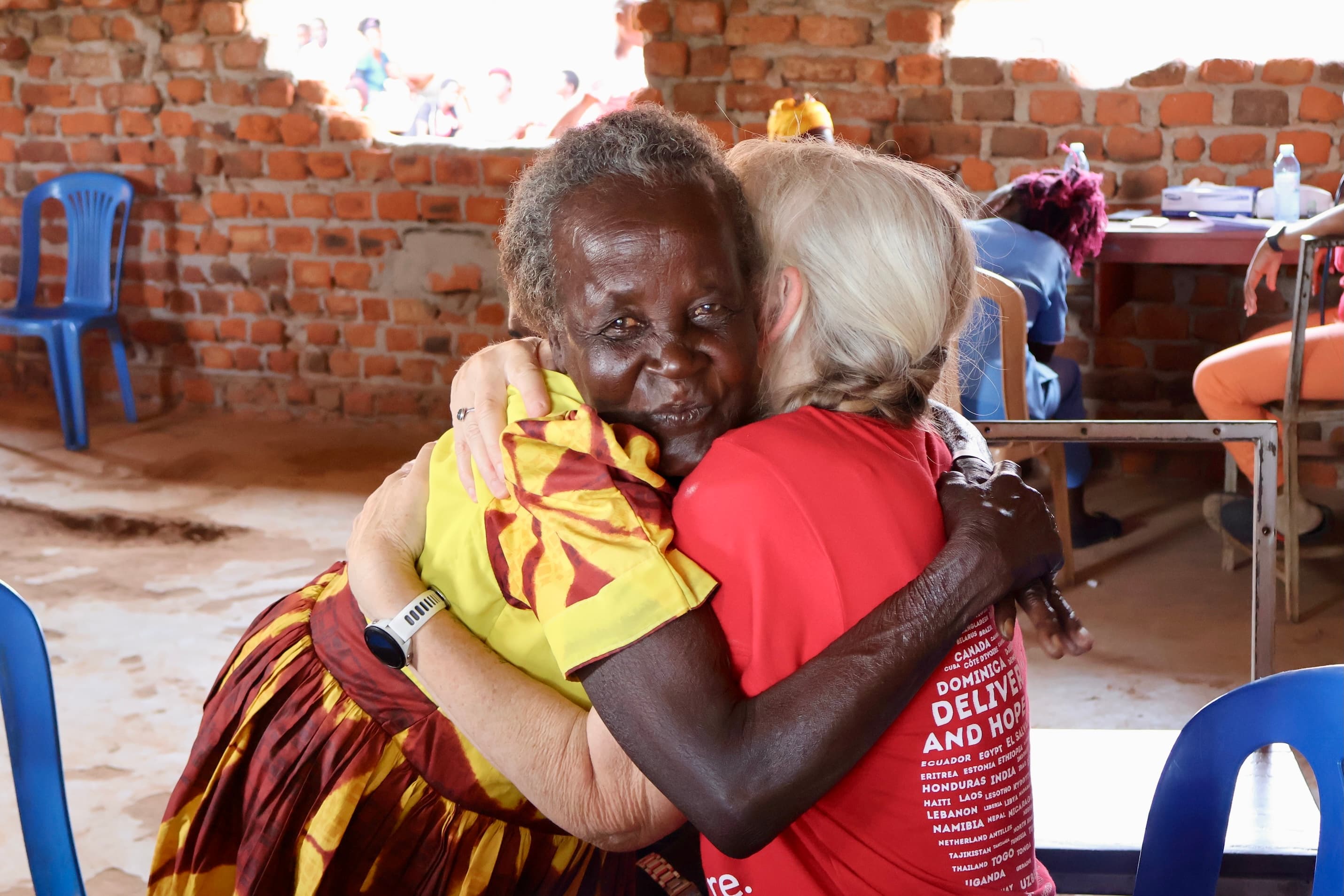 Smiling woman giving a piggyback ride to a laughing young girl.